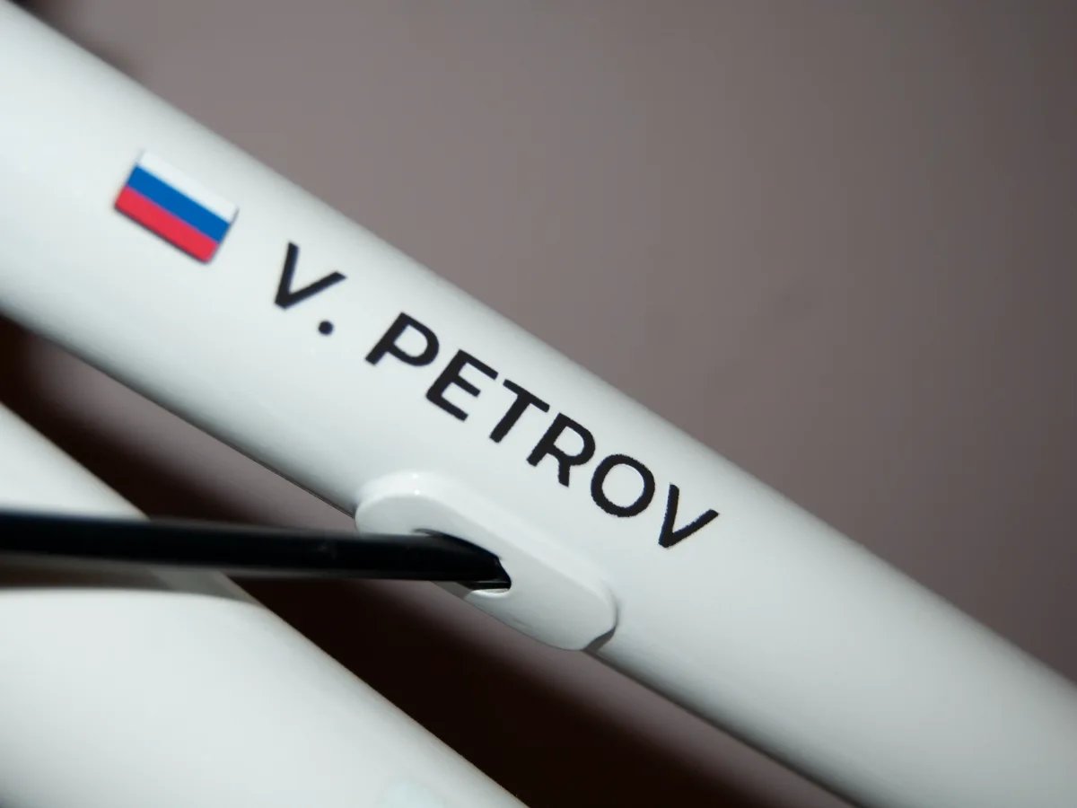 Чёрная наклейка V. PETROV на белой раме